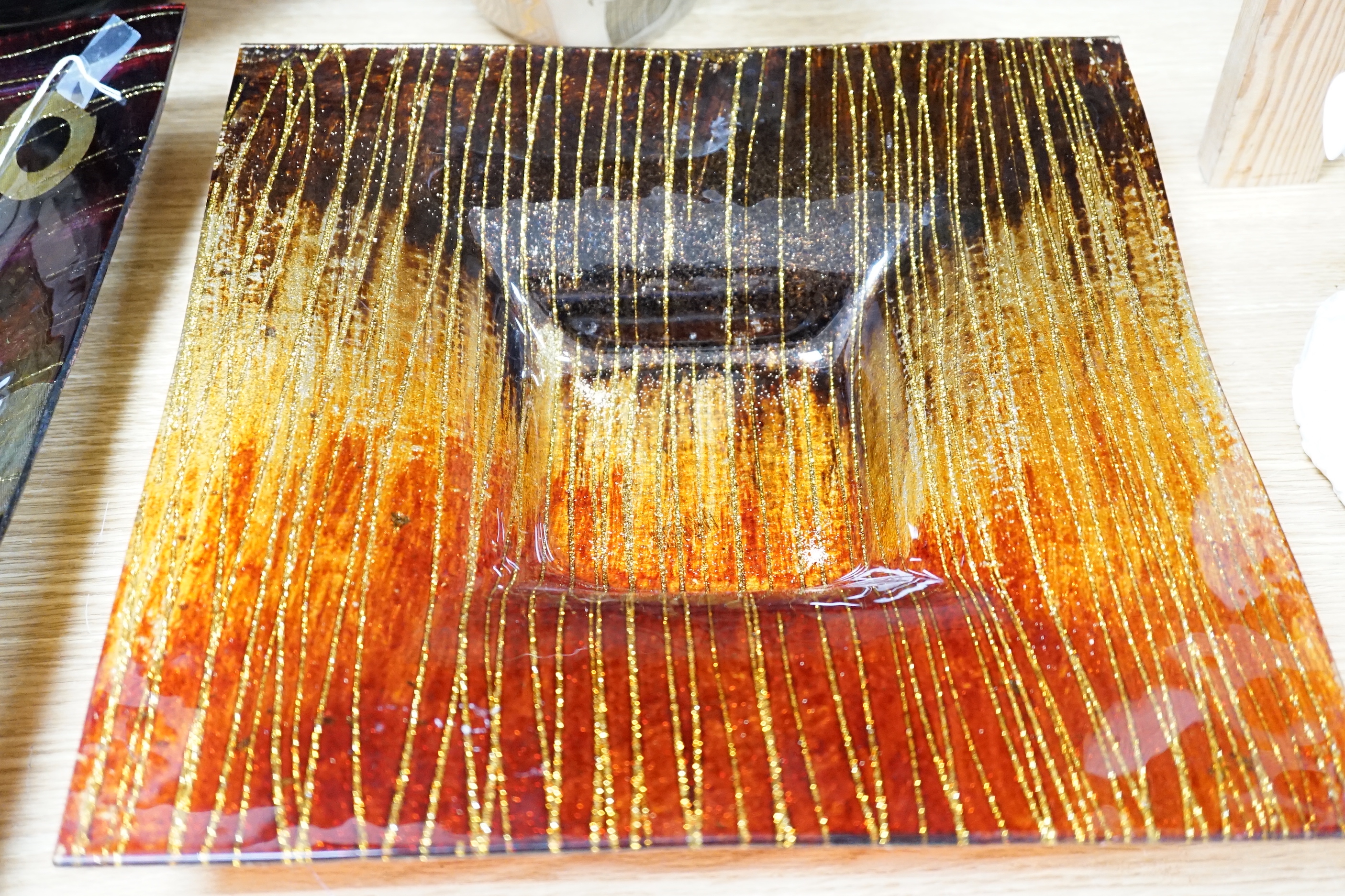 A faux tortoiseshell glass vase, an art glass vase and two Art glass dishes, the largest 41cm wide